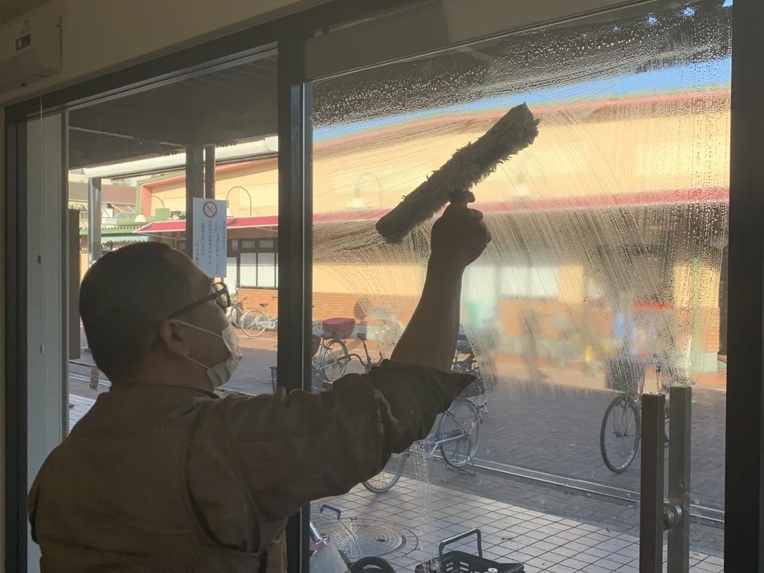 ガラス面を清掃するスタッフ