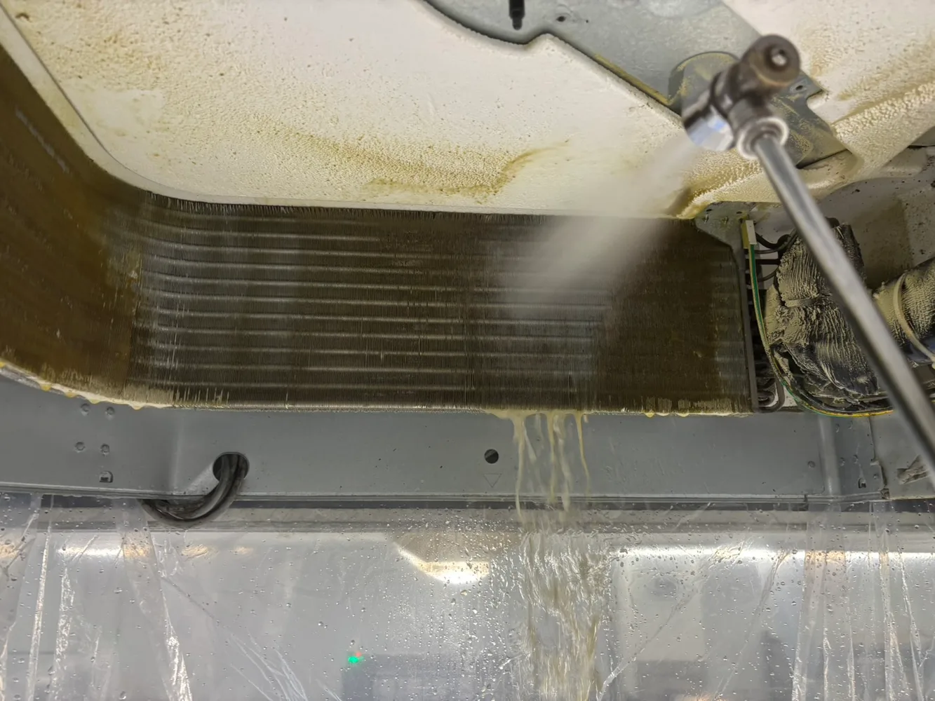 空調機内部を高圧洗浄する作業